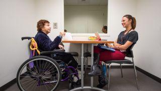 student talking to woman in wheelchair